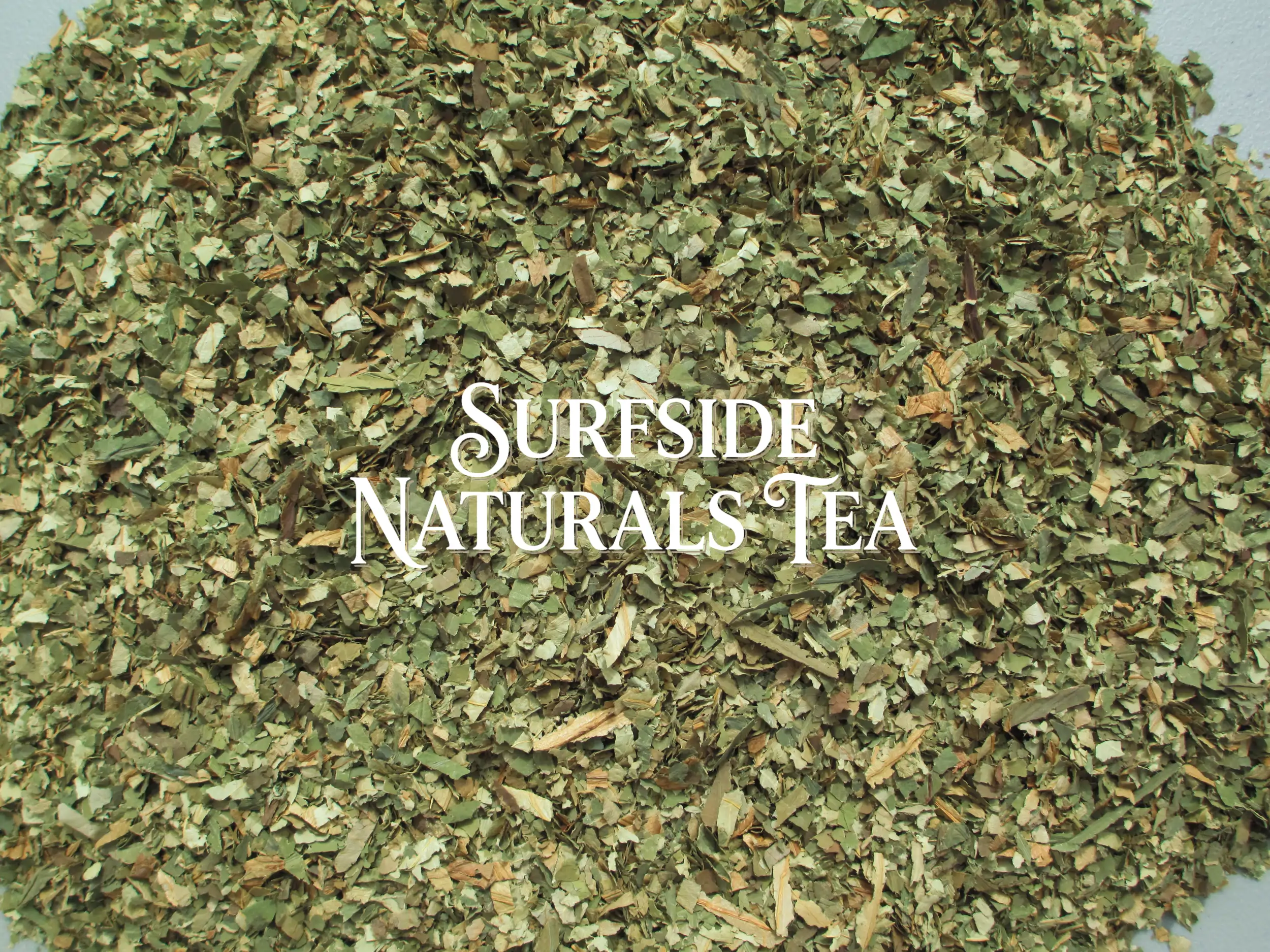 A pile of clean, dried sacred lotus leaves cut into pieces about ¼ to ½ inch wide and 1–2 inches long, ranging from light to dark green with some tan pieces, with a "Surfside Naturals Tea" watermark in the center.
